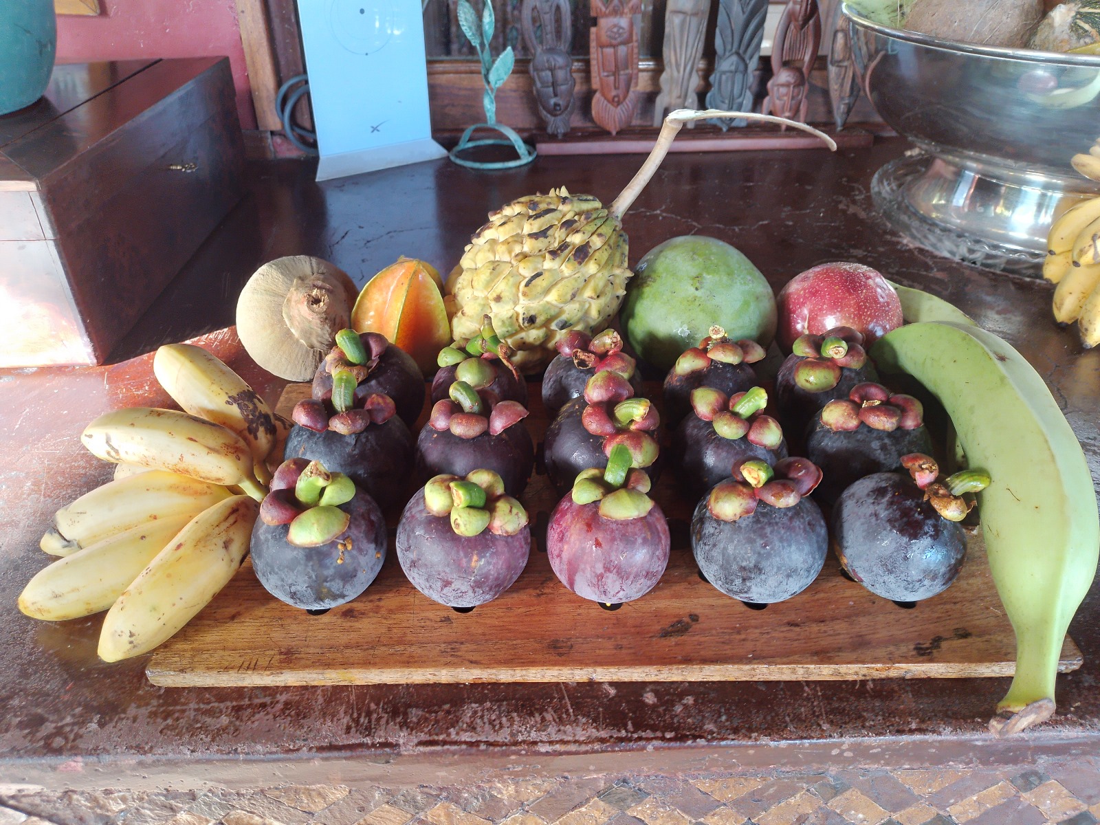 Mangoustans, bananes, pomme cannelle, mangue et carambole du domaine sur planche de bois