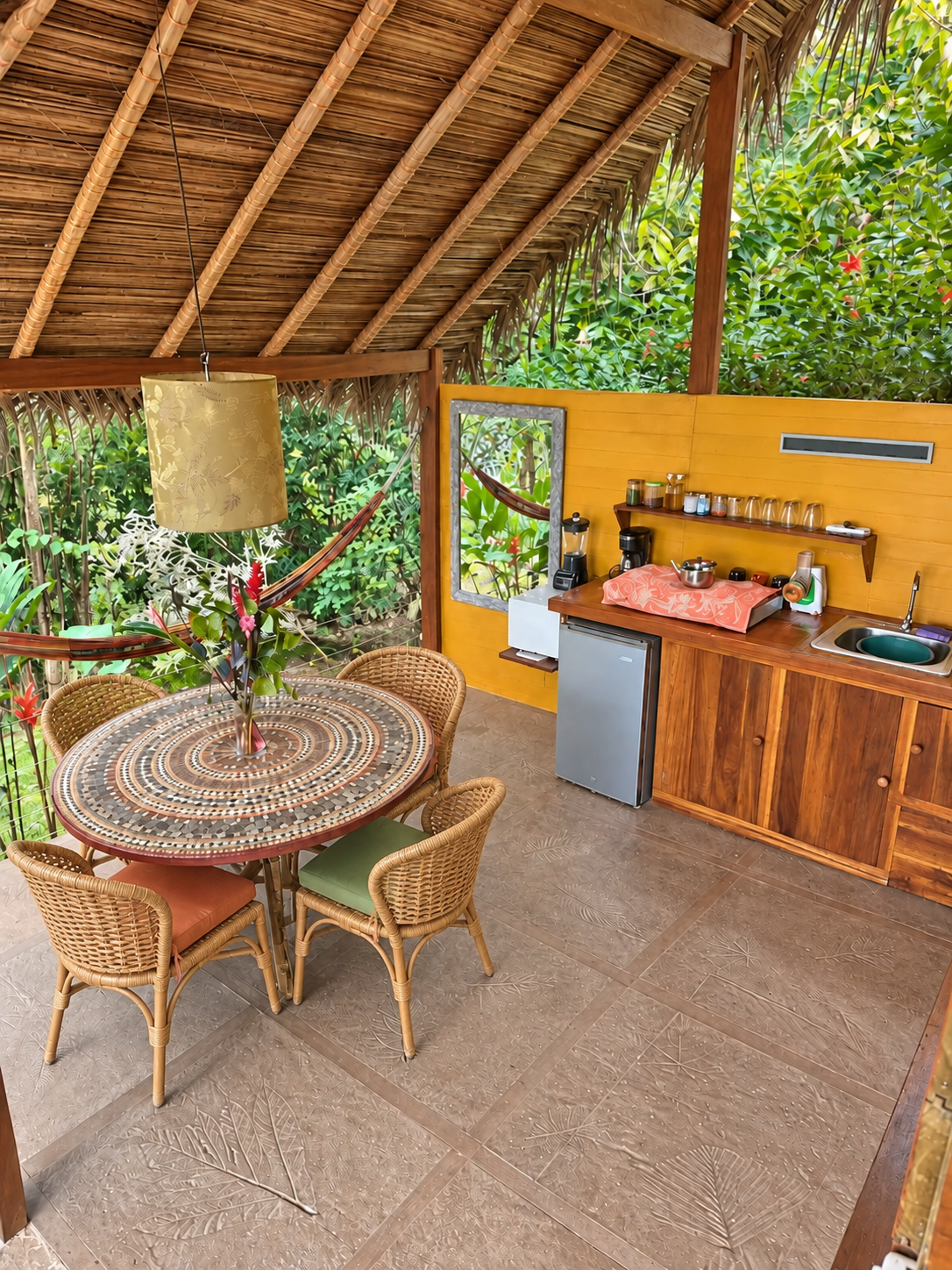 Cuisine extérieure couverte avec table mosaïque et hamac